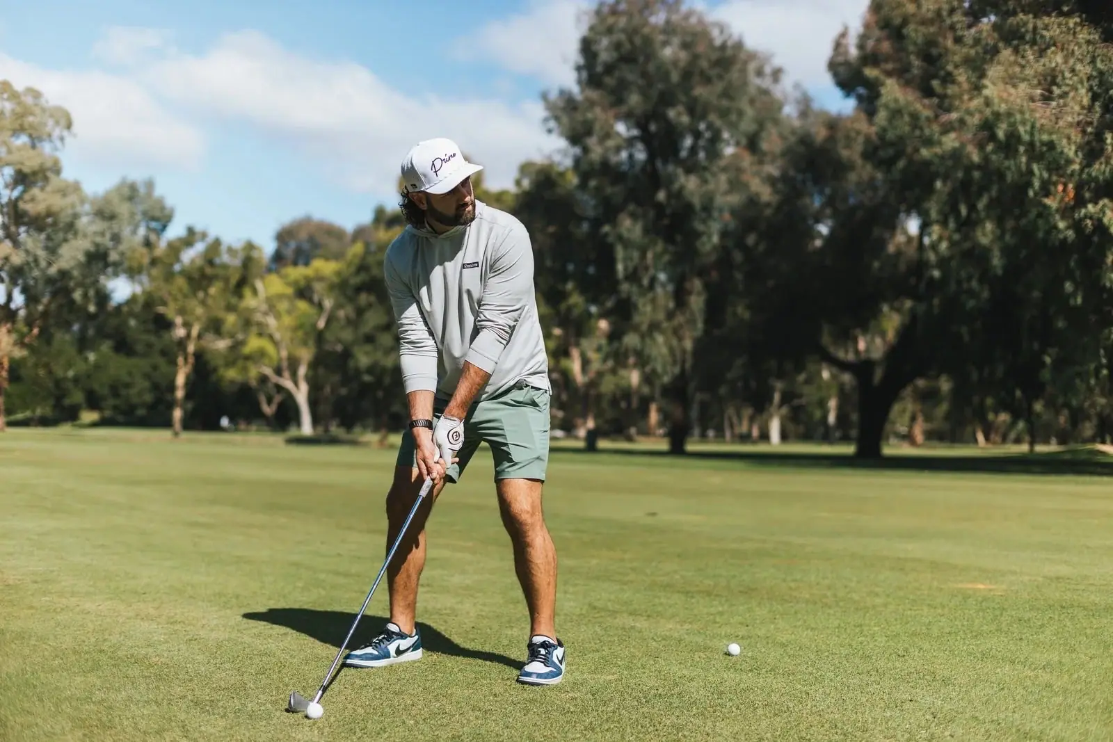A golfer lining up a shot in Tee Game apparel